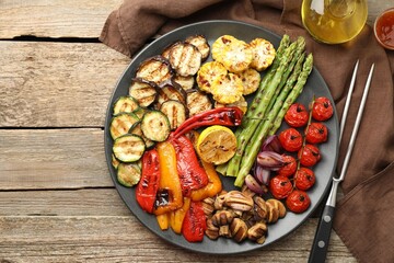 Wall Mural - Delicious grilled vegetables served on wooden table, flat lay