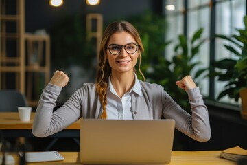 Young fitness employee business woman wear shirt casual clothes glasses sit work at office desk with pc laptop show biceps muscles on hand demonstrating strength power, raised arms