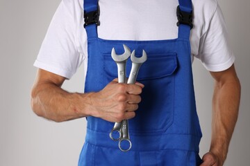 Wall Mural - Auto mechanic with wrenches on light grey background, closeup