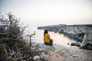 woman watching the sunset over the town of bonifacio corsica island france