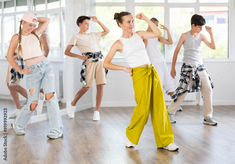 Young girl in bright clothes, together with group of teenage friends ...