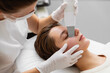 © callisto - Aesthetician performing facial treatment on a client in a modern skincare clinic