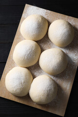 Poster - Raw dough balls on black wooden table, top view