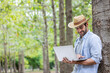 © kamonrat - Farmer Using Laptop in Forest, Embracing Digital Technology for Environmental Data Collection and Sustainable Forestry Practices