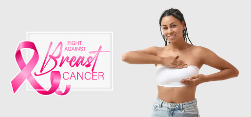 Wall Mural - Young African-American woman checking her breast on white background. Cancer awareness concept