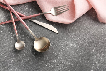 Wall Mural - Silver cutlery with pink kitchen towel on grey grunge background