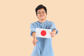 Sticker - Young Asian man with flag of Japan on beige background