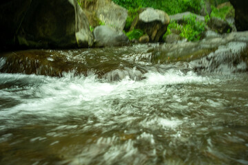 Flowing river water movement between mountain rocks in close-up. beautiful mountain river flow scene with fast flowing water and pebbles. rapid current Flowing river water in beautiful scenery.