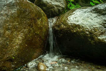 Flowing river water movement between mountain rocks in close-up. beautiful mountain river flow scene with fast flowing water and pebbles. rapid current Flowing river water in beautiful scenery.