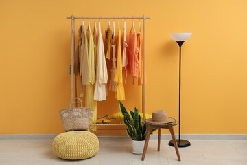 Canvas Print - Female clothes hanging on rack against yellow background