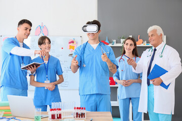 Wall Mural - Male medical student with surgical instruments using VR glasses at lecture