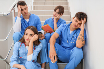 Poster - Tired medical students sitting on stairs at university