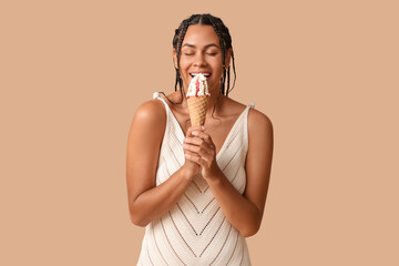 Sticker - Beautiful young African-American woman eating sweet ice-cream in waffle cone on brown background