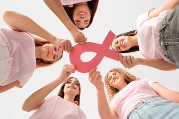 Wall Mural - Beautiful women with pink ribbon on color background, bottom view. Breast cancer awareness concept