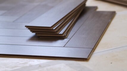 Poster - Laying laminate flooring in a new apartment, the laminate is stacked and laid on the floor. Repair with your own hands.
