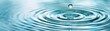 © Mont - A close-up view of a water droplet creating ripples in clear blue water, evoking a sense of calm and tranquility.