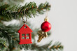 © samina - A red Christmas house key is hanging on the green branch of a Christmas tree