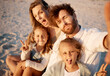 © peopleimages.com - Mom, dad and children in selfie at beach, funny face or smile with care, love or tongue out for summer memory. Father, mother and daughter kids with peace sign, family or portrait on holiday in Spain
