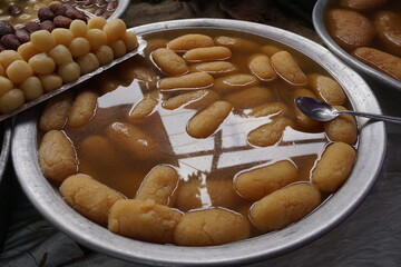 Popular Bangladeshi dessert Gulab Jamun with sugar syrup, Traditional Bangladeshi sweet called rasgulla or rasgoola is being sold at a market, Gulab jamun and rasgulla are displayed together