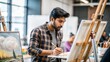 © N7 - An Indian student working on an art project in a university art studio, with art supplies and canvases in the background.