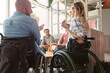 © Robert Kneschke - People in wheelchairs engaging in a discussion with friends in a bright setting