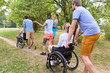 © Robert Kneschke - Group of friends enjoying a park outing, including persons in wheelchairs engaging in conversation