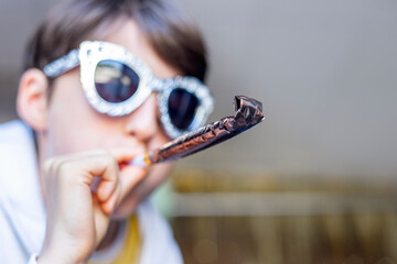 Child in party glasses with party blower close-up