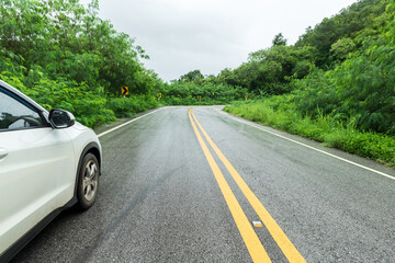 Wall Mural - Wet asphalt road and side rear-view mirror on a car.