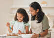 © DavisShared/peopleimages.com - Baking, happy and mom with girl in kitchen with icing for cake, cupcakes and dessert. Family, home and mother and child with ingredients, recipe and learning for bonding, relationship or fun together