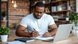 © Pinklife - A focused man in a white shirt writes in a notebook at a wooden desk surrounded by books and plants, illustrating a moment of concentration and productivity.
