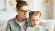 © Intelligent Horizons - A mother and her young daughter sitting together on a couch surrounded by maps travel brochures and other vacation planning materials