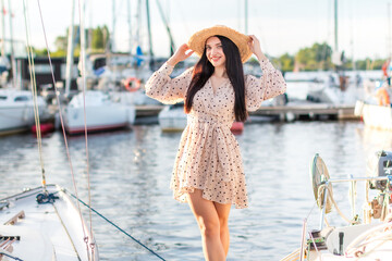 Young tourist women happy enjoing to the side walking in yacht harbour. A woman enjoys a holiday by the sea.  