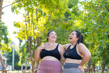 LGBTQ couple.Two smiling sporty young chubby overweight women in sportswear walking in park after workout. fitness sport club, body and health care. Outdoor Activity