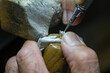 © CesareFerrari - Macro shot of a goldsmith's hands at work on a diamond ring.