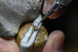© CesareFerrari - Macro shot of a goldsmith's hands at work on a diamond ring.