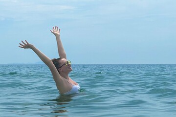 Wall Mural - portrait of a beautiful young woman on vacation enjoying a holiday at sea, concept positive, relaxation, glasses