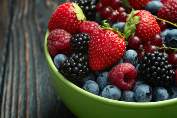 Wall Mural - Mix of ripe colorful berries in bowl photography . Blueberry , strawberry , raspberry , blackberry and red currant . Top view