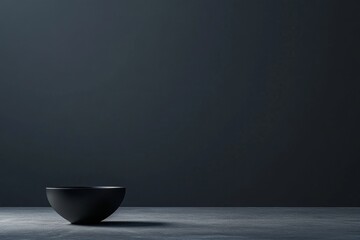 Poster - A sleek black bowl rests on a surface, illuminated softly, contrasting with the dark gradient of the background, creating a serene and modern aesthetic