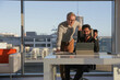 © Caia Image - Businessmen talking in office; Two businessmen looking at digital tablet and talking in modern office at desk