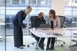 © Caia Image - Businesswomen talking in office; Three smiling businesswomen talking in modern conference room in office