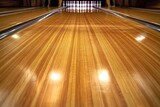 The polished wooden floor of a bowling alley extends toward a set of illuminated pins in the distance, creating an inviting atmosphere for bowlers