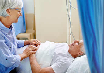 Wall Mural - Hospital, bed and old man with wife, sick and senior care with health insurance, holding hands and smile. Couple, talking and healthcare for elderly person, medical and love in clinic and illness