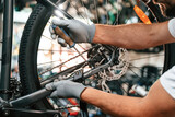 Fixing the derailleur. Close up view of man's hands that is repairing bicycle
