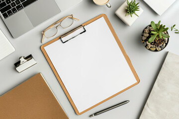 Minimalistic and organized workspace featuring a clipboard with blank paper, laptop, and plants on a white desk.