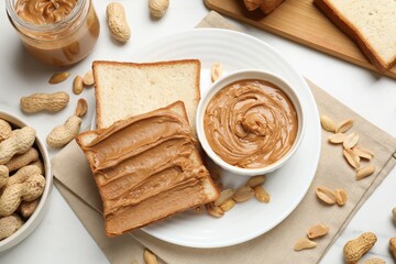 Canvas Print - Delicious sandwich with peanut butter and fresh nuts on white table, flat lay