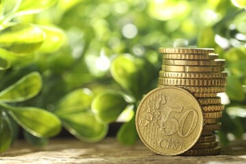 Stacked euro coins on wooden table outdoors