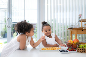 The older sister fed cookies to the younger sister as a snack before the main dinner