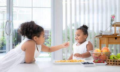 The older sister fed cookies to the younger sister as a snack before the main dinner