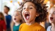 © LifeMedia - An enthusiastic child with curly hair sings with mouth wide open, surrounded by friends, expressing pure joy and excitement in a lively indoor setting.