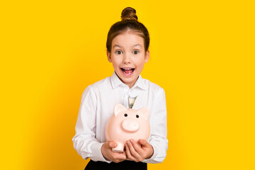 Sticker - Photo of cute schoolgirl hold money bank pig wear uniform isolated on yellow color background